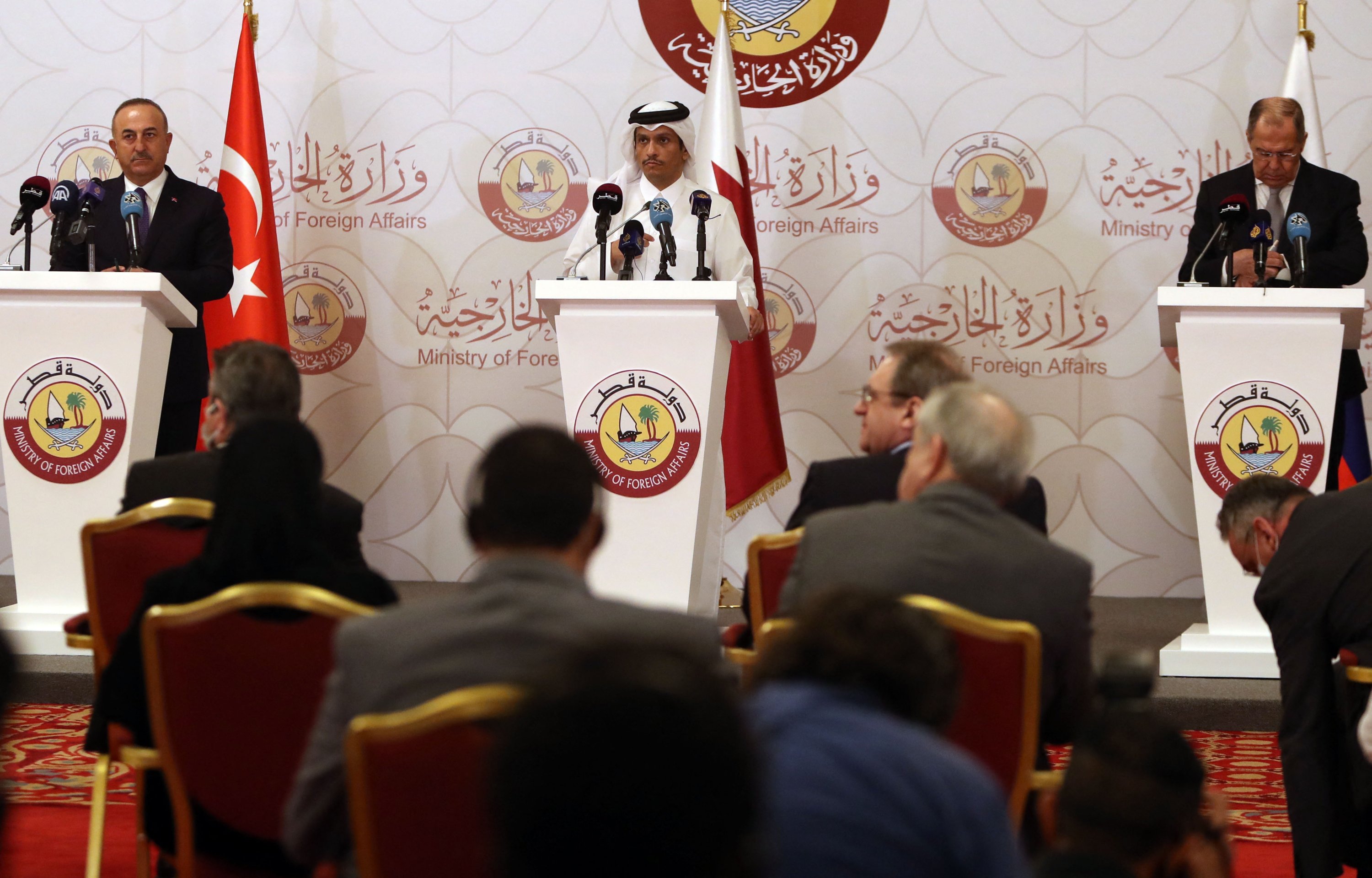 Turkish Foreign Minister Mevlüt Çavuşoğlu (L), Qatari Foreign Minister Sheikh Mohammed bin Abdulrahman Al Thani (C) and Russian Foreign Minister Sergei Lavrov give a joint press conference following a tripartite meeting in Doha, Qatar, March 11, 2021. (Photo by KARIM JAAFAR via AFP)