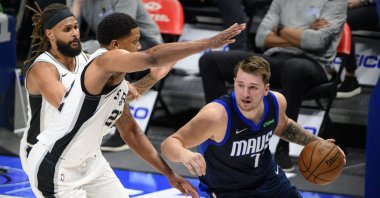 Dallas Mavericks guard Luka Doncic (R) dribbles the ball past San Antonio Spurs forward Rudy Gay (L) during an NBA game at the American Airlines Center, Dallas, Texas, March 10, 2021. (Reuters Photo)