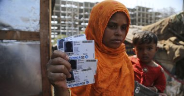Rahima kato, a Rohingya woman displays identity cards of her family members issued by United Nations High Commissioner for Refugees (UNHCR) at their makeshift camp on the outskirts of Jammu, India, March 9,2021. (AP Photo)