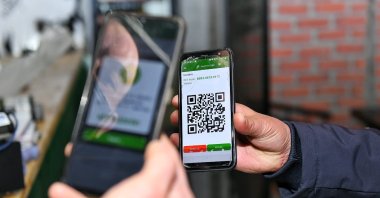 A police officer checks the HES code of an individual, Istanbul, Turkey, March 9, 2021. (IHA Photo)