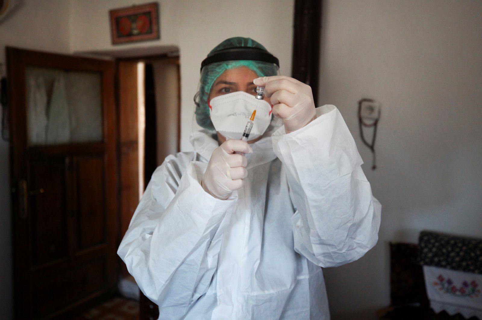 A nurse prepares a dose of Sinovac's COVID-19 vaccine CoronaVac, for an elderly man at his home as nationwide vaccination continues for seniors, Ankara, Turkey, March 3, 2021. (Reuters)