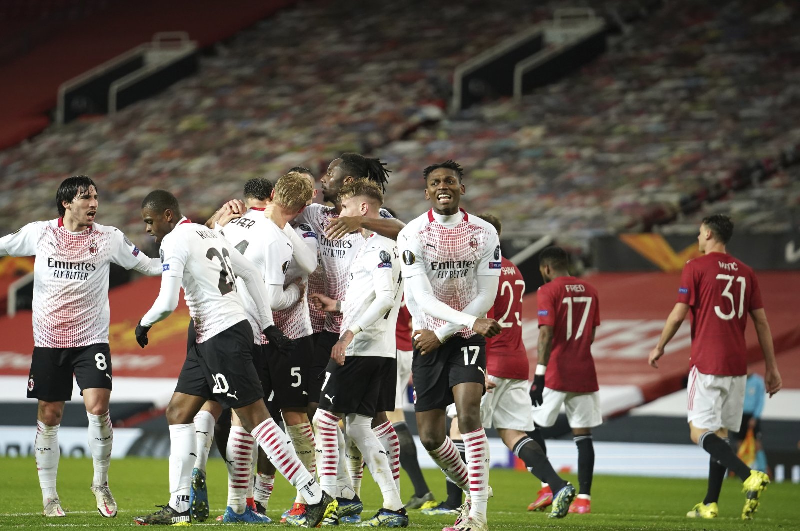 AC Milan players celebrate after Simon Kjaer scored Milan side's opening goal during the Europa League round of 16 first leg football match between Manchester United and AC Milan at Old Trafford in Manchester, England, March 11, 2021. (AP Photo)