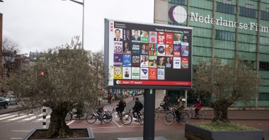 Cyclists at a road crossing near Dutch political party election campaign posters on a billboard in Amsterdam, Netherlands, on Tuesday, March 9, 2021. (Getty Images)