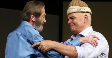 Actor Ferhan ﬁensoy (L) hands the kavuk to Rasim Öztekin at Ses Theater in Istanbul, May 12, 2016. (AA Photo) 