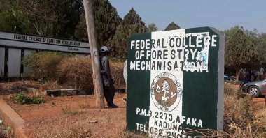 A man rests on a pole beside the signage of the Federal College of Forestry Mechanisation where gunmen abducted students, in Kaduna, Nigeria March 12, 2021. (Reuters Photo)