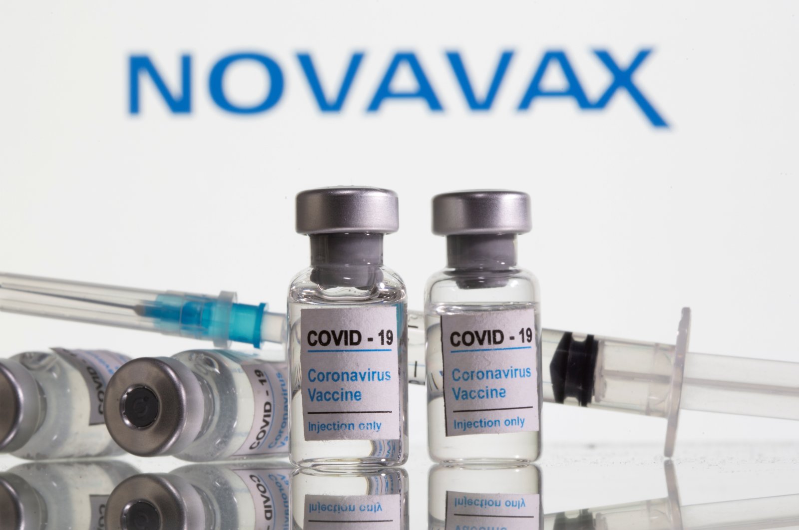 Vials labeled "COVID-19 Coronavirus Vaccine" and a syringe are seen in front of the Novavax logo in this illustration taken on Feb. 9, 2021. (Reuters Photo)
