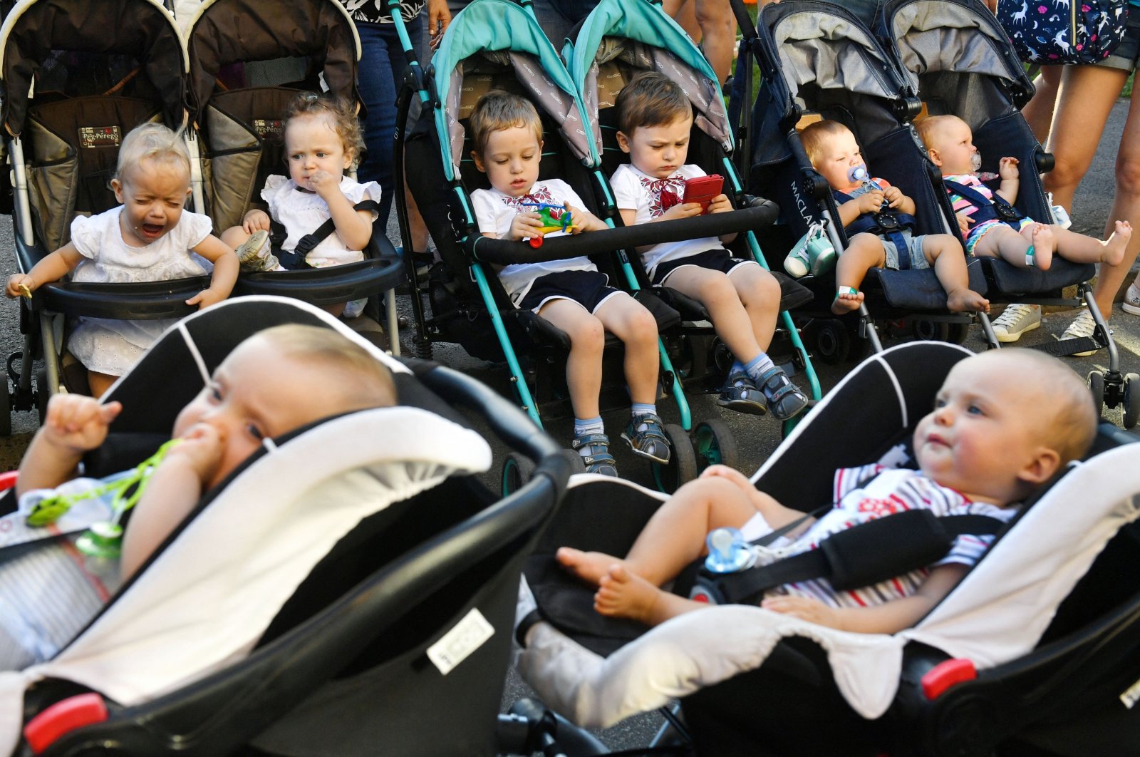 Twins and triplets sit in their stroller as they arrive for the children's Festival Of Twins, in Kyiv, Ukraine, Aug. 11, 2018. (AFP Photo)