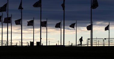 A pedestrian jogs around the Washington Monument at dusk in Washington, U.S., Feb. 16, 2021. (Reuters)