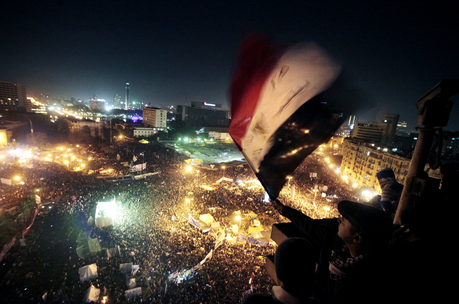 People wave flags in Tahrir Square to mark the first anniversary of the popular uprising that led to the quick ouster of autocrat President Hosni Mubarak, in Cairo, Egypt on Jan. 25, 2012 (AP File Photo)