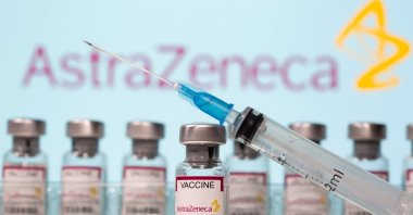 Vials labelled "AstraZeneca COVID-19 Coronavirus Vaccine" and a syringe are seen in front of a displayed AstraZeneca logo in this illustration photo taken March 10, 2021. (Reuters Photo)