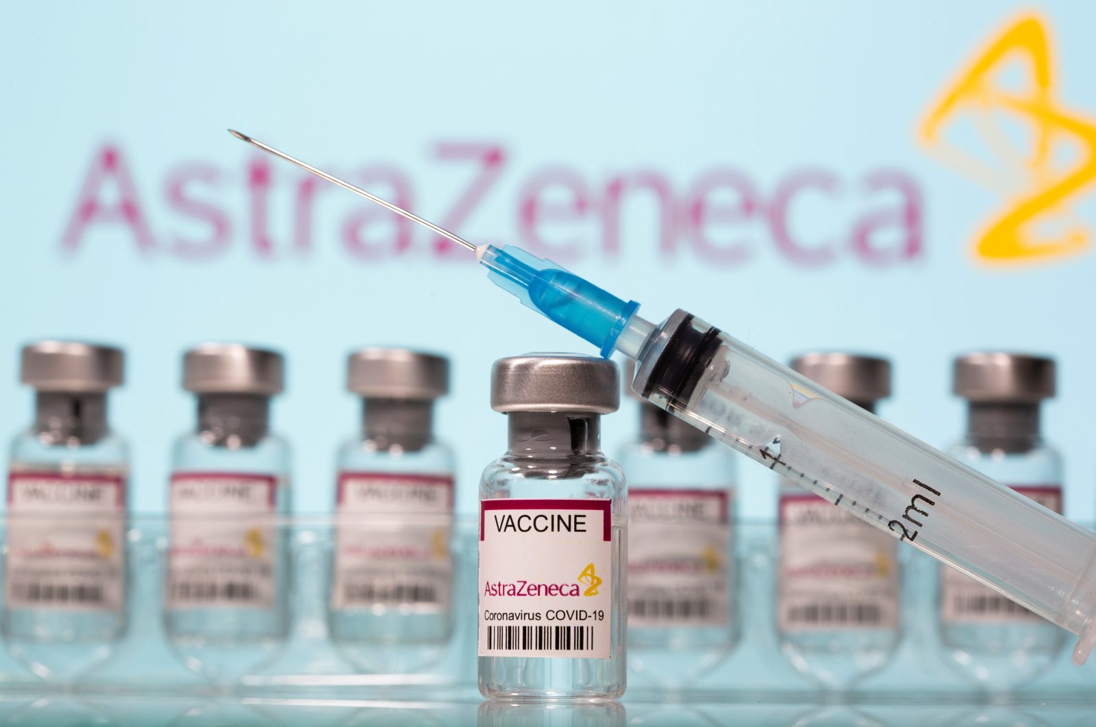 Vials labelled "AstraZeneca COVID-19 Coronavirus Vaccine" and a syringe are seen in front of a displayed AstraZeneca logo in this illustration photo taken March 10, 2021. (Reuters Photo)