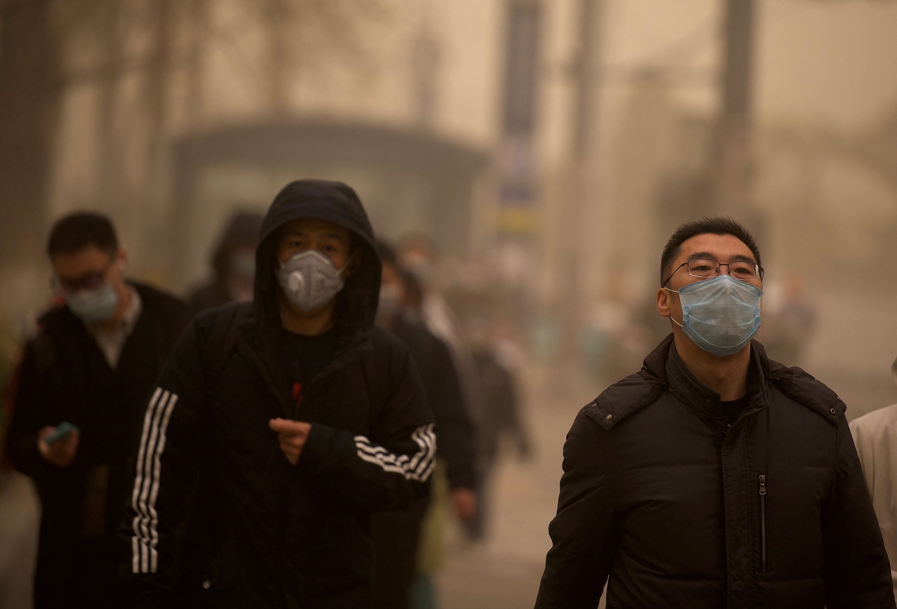 People walk along a street during a sandstorm in Beijing, China, March 15, 2021. (AFP Photo)