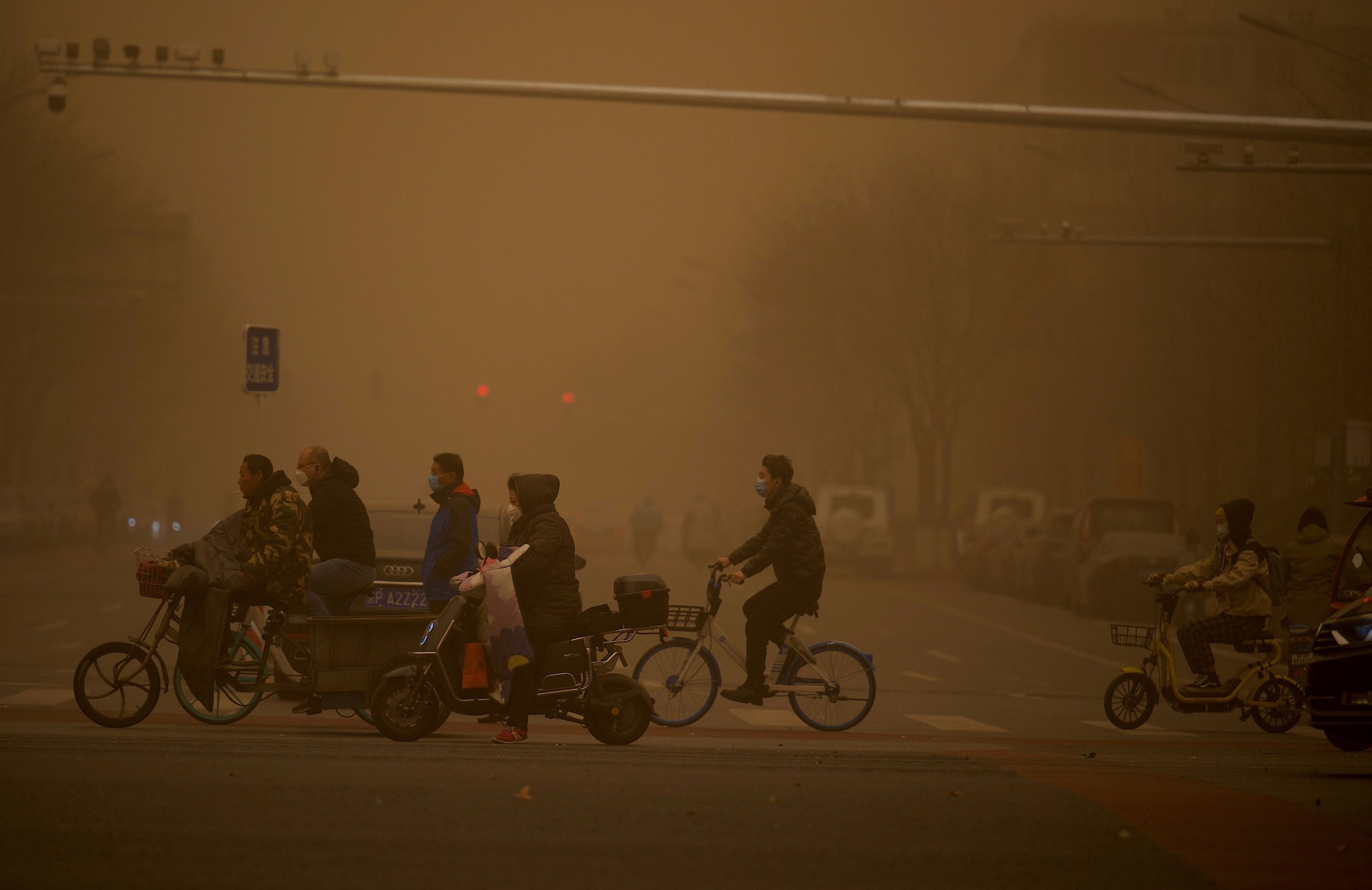 People cross a street during a sandstorm in Beijing, China, March 15, 2021. (AFP Photo)