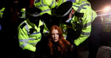 Police detain a woman as people gather at a memorial site in Clapham Common Bandstand, following the kidnap and murder of Sarah Everard, in London, U.K., March 13, 2021. (Reuters Photo)