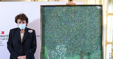 French Culture Minister Roselyne Bachelot poses next to a spoiled oil painting by Gustav Klimt painted in 1905 called "Rosebushes under the Trees," during a ceremony at the Orsay museum in Paris, France, March 15, 2021. (AP Photo)