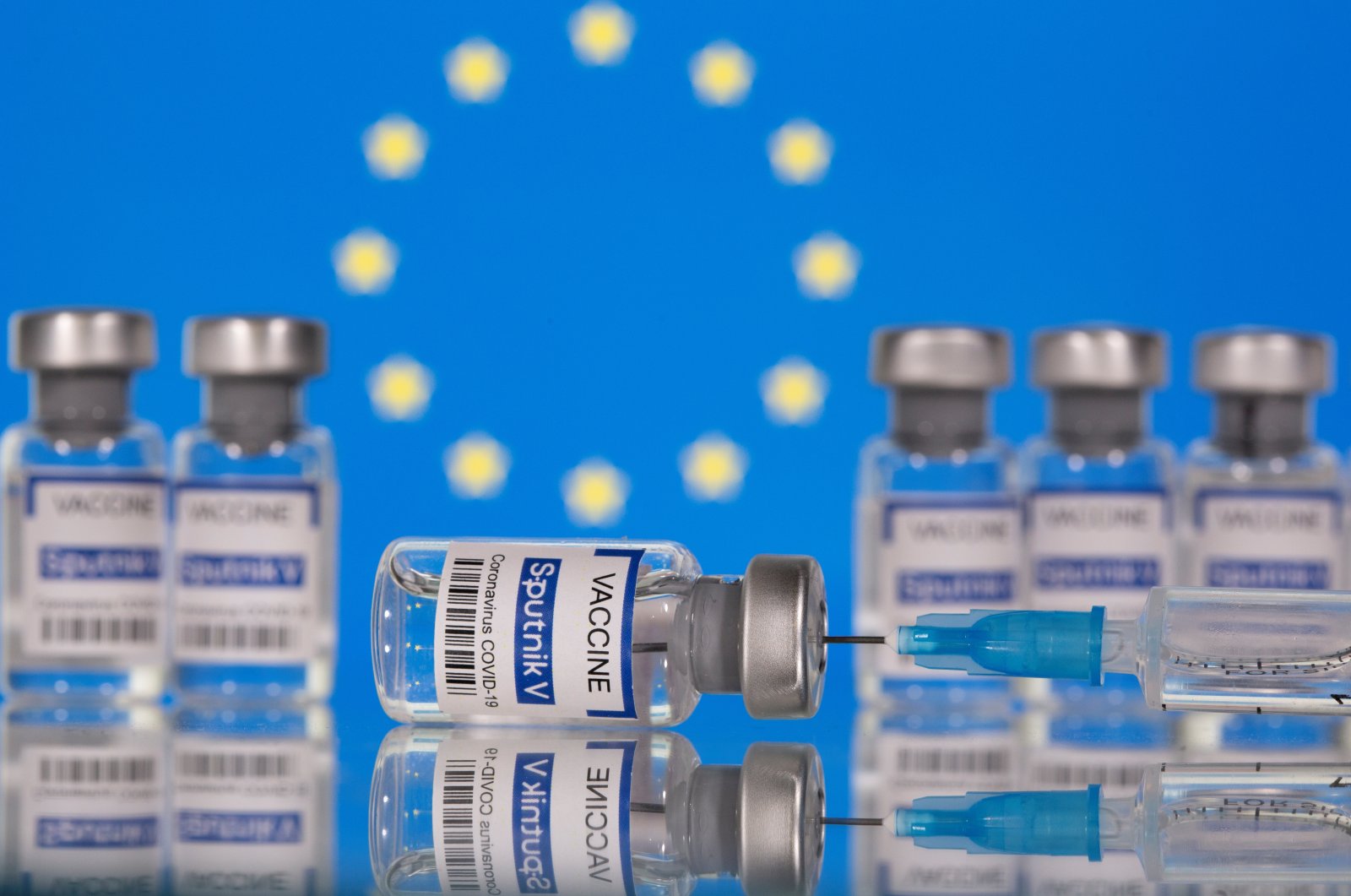 Vials labeled "Sputnik V Coronavirus COVID-19 Vaccine" and a syringe are seen in front of an EU flag, in this illustration photo taken on March 12, 2021. (Reuters Photo)
