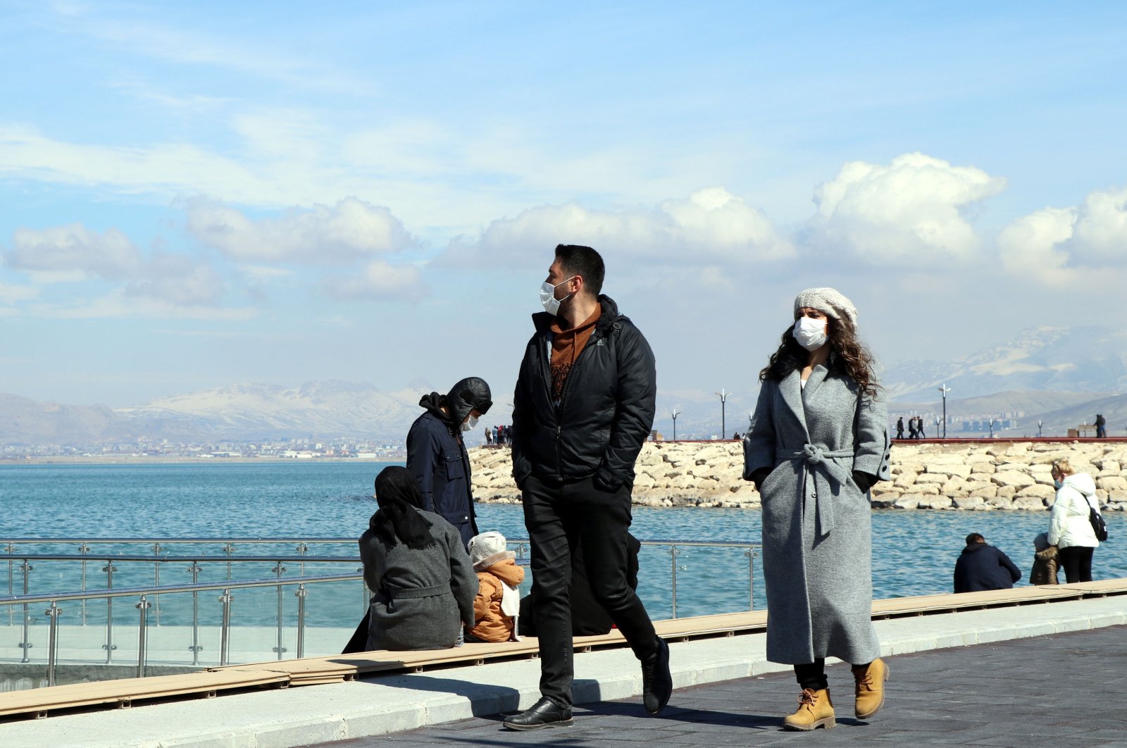 People wearing protective masks walk on the shore of Lake Van, in Van, eastern Turkey, March 14, 2021. (DHA PHOTO)