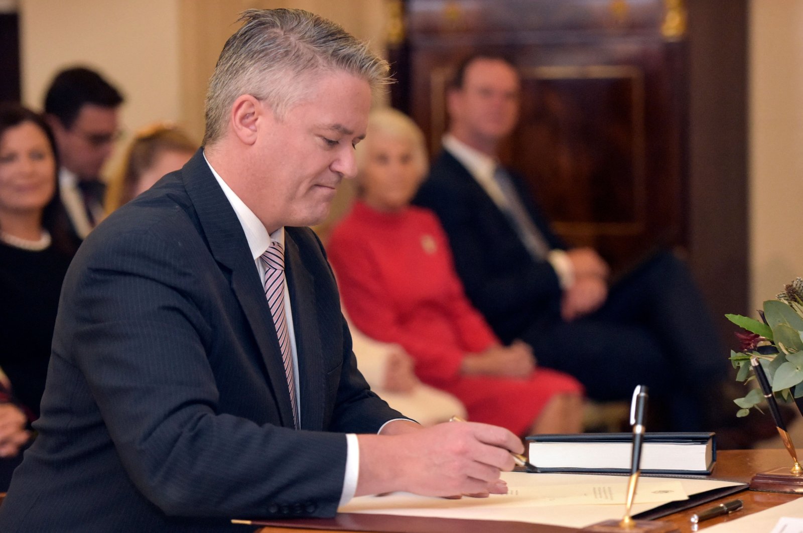 Mathias Cormann signs a document during an oath-taking ceremony at the Government House in Canberra on May 29, 2019. (AFP File Photo)