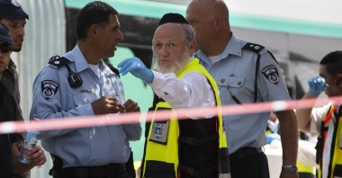Yehuda Meshi-Zahav, the head of Israel's ZAKA rescue service, center, stands at the scene of a shooting attack, in Jerusalem, Israel, Oct. 13, 2015. (AP Photo)
