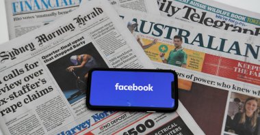 An illustration image shows a phone screen with the "Facebook" logo and Australian newspapers in Canberra, Australia, Feb. 18, 2021. (Reuters Photo)