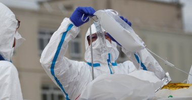 A medical crew from Angers hospital carries a patient suffering from the coronavirus disease (COVID-19) on a stretcher after his transfer by French SAMU rescue team helicopter, from the Ile de France region to Angers hospital, France, March 15, 2021. (Reuters Photo)