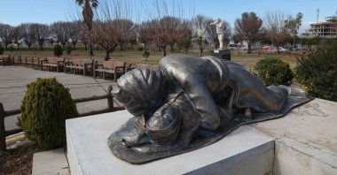 A statue depicting a Kurdish father holding his baby, both killed in the 1988 Halabja Massacre, is part of a memorial monument dedicated to the victims of the attack in the town, Iraq, March 13, 2021. (AFP Photo)