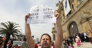 A Turkish man holds pictures of Turkish officials, including ambassadors and consuls, who were killed by a terrorist belonging to the now-defunct Armenian Secret Army for the Liberation of Armenia (ASALA), in response to a demonstration to commemorate the 1915 events in the Ottoman Empire, in front of the historical Haydarpaşa station in Istanbul, Turkey, April 24, 2010. (Reuters Photo)