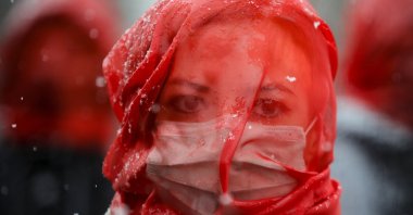 A woman wears a red veil during a flashmob to raise awareness of the increased levels of violence against women since the COVID-19 pandemic started one year ago, in Bucharest, Romania, March 10, 2021. (AP Photo)