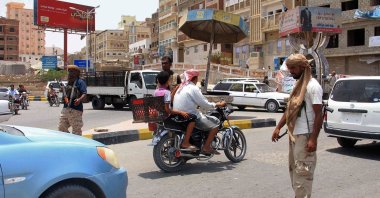 Yemeni security forces inspect vehicles at a checkpoint in Mukalla, the capital of Yemen's southeastern Hadramawt province, a day after 11 people were killed and 18 were wounded in twin bombings in the area, July 19, 2016. (AFP Photo)