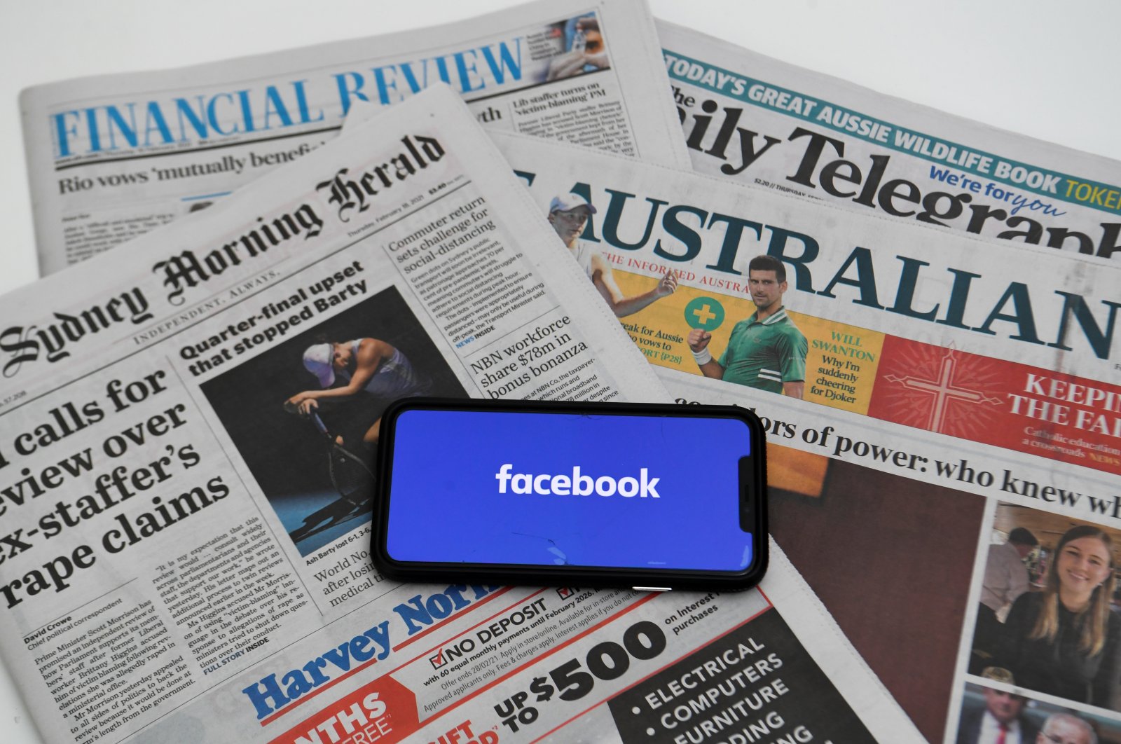 An illustration image shows a phone screen with the "Facebook" logo and Australian newspapers in Canberra, Australia, Feb. 18, 2021. (Reuters Photo)