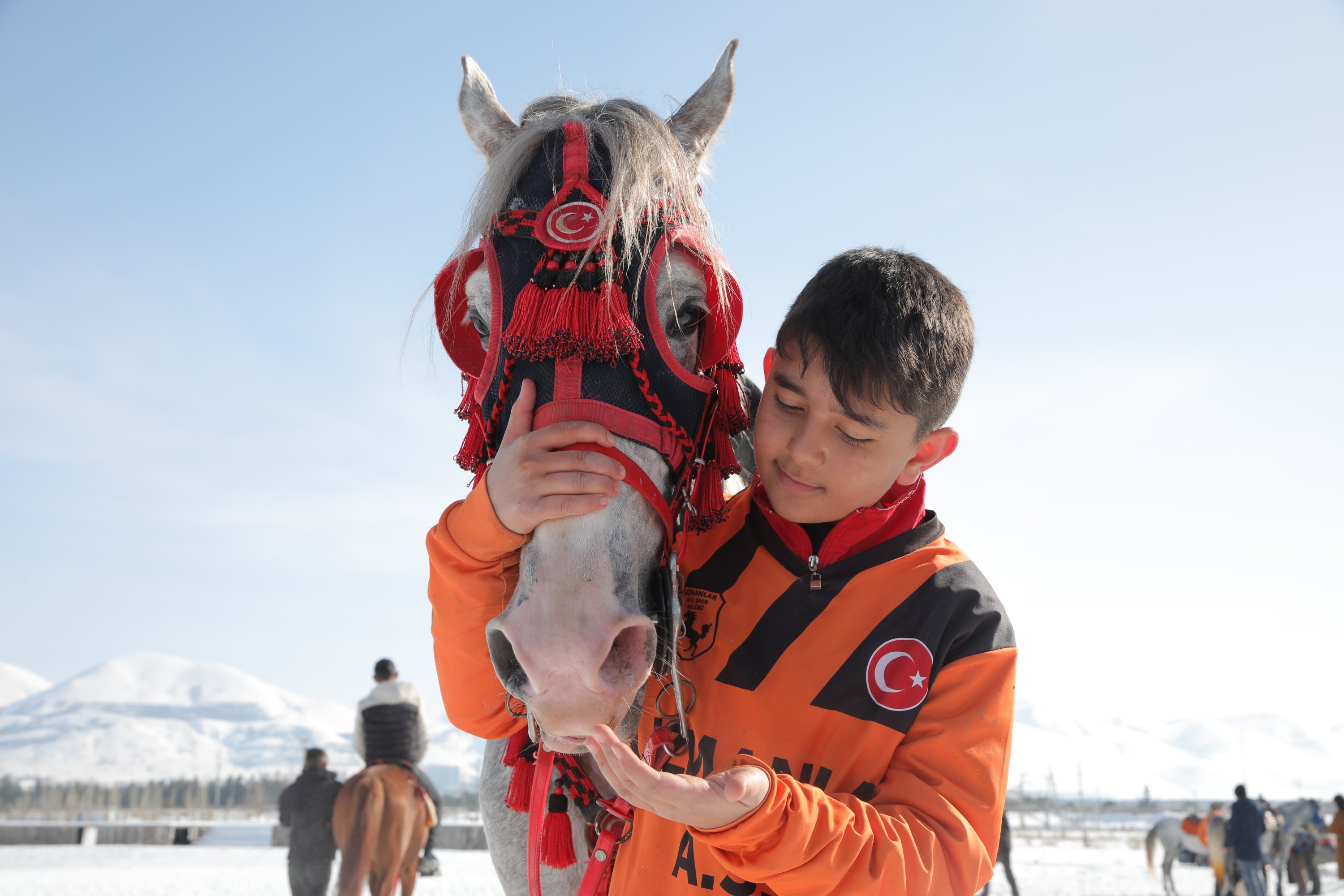 Thirteen-year-old Muhammed Rasit, the youngest member of Uzmanlar Sports Club, cuddles his horse prior to a game of cirit, Erzurum, eastern Turkey, Friday, March 5, 2021. (AP Photo)
