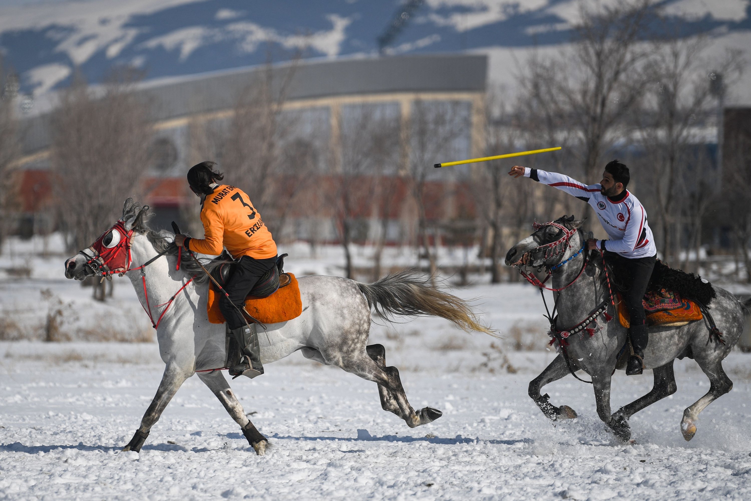 A competitor (R) prepares to throw a javelin toward an opponent during a Turkish cirit game, Erzurum, eastern Turkey, March 5, 2021.