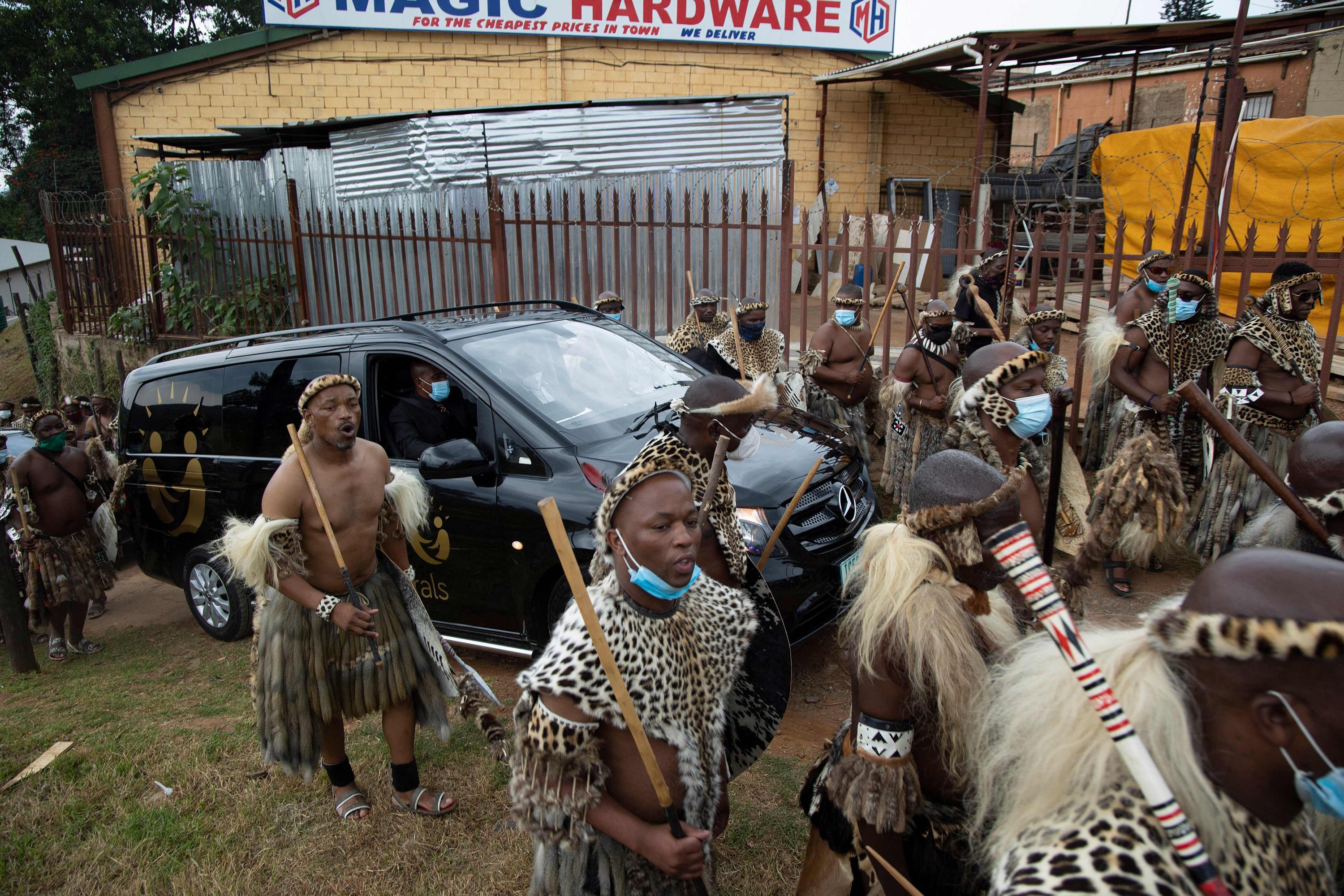 Zulu regiments, also known as amaButho, form a guard of honor as they escort a hearse carrying the body of King Goodwill Zwelithini from a mortuary in Nongoma, KwaZulu Natal, South Africa, March 17, 2021. (Photo by Phill Magakoe / AFP)