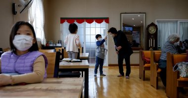Lyoo Chan-hee, 10, checks the body temperature of a resident before a church service on Nokdo island in Boryeong, South Korea, Feb. 28, 2021. (Reuters Photo)