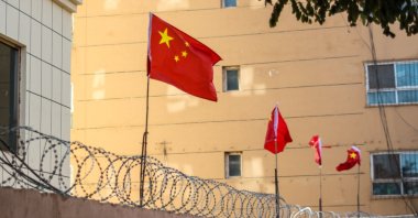 Chinese flags line a barbed wired wall in Kashgar, Xinjiang, China. (Shutterstock Photo)