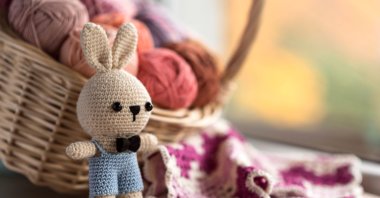 A little bunny amigurumi next to a granny square. (Shutterstock Photo)