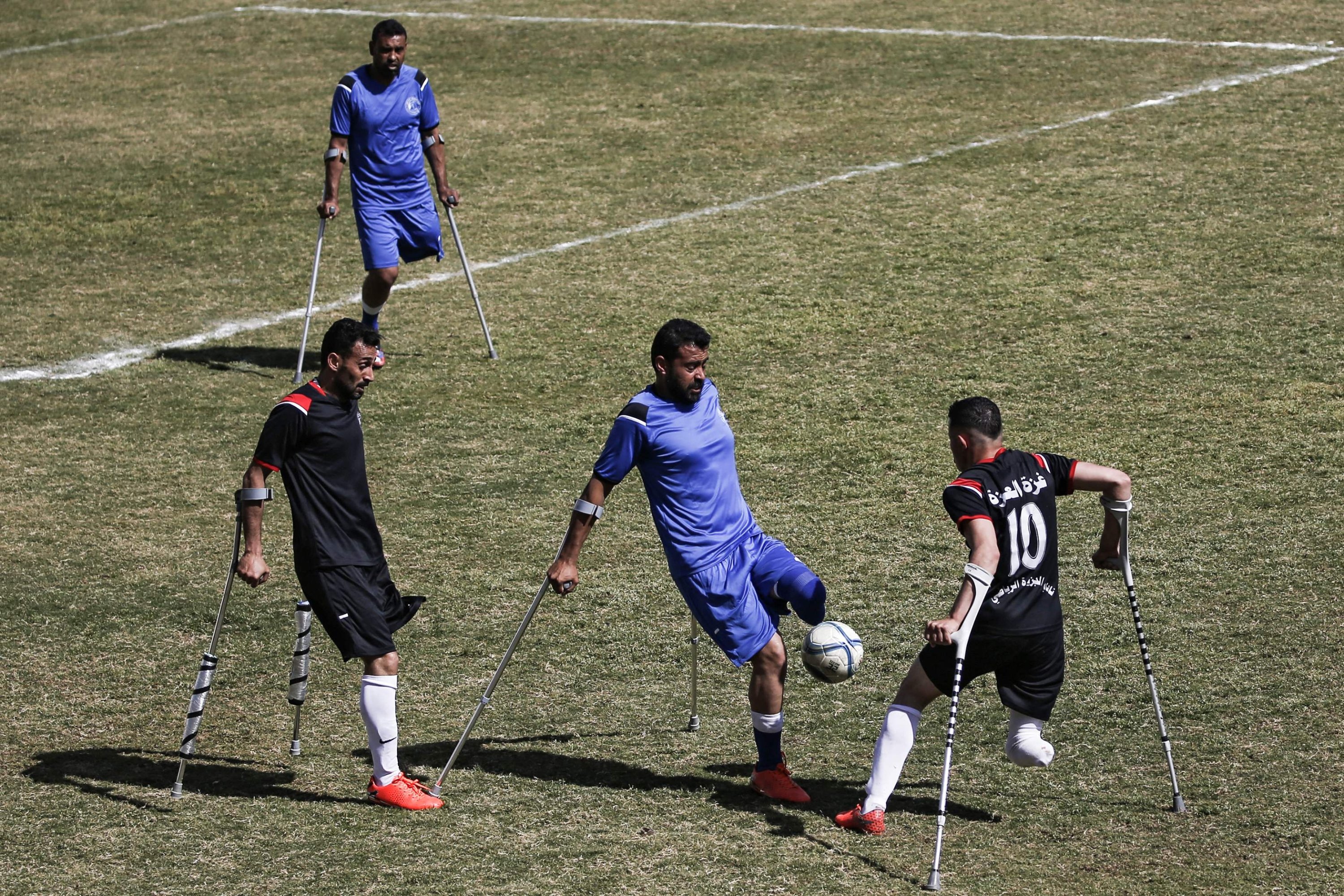 Palestinian players vie for the ball during the final of a local football championship for amputees, Gaza City, March 18, 2021. (AFP Photo)
