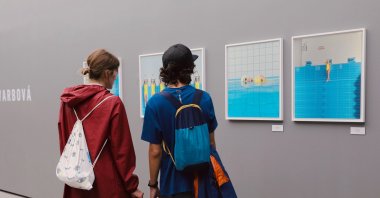 Two visitors examine photos at 212 Photography Istanbul, Turkey, 2020.