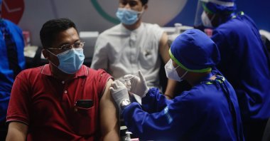 Two men receive shots of COVID-19 vaccines during a mass vaccination drive in Jakarta, Indonesia, March 15, 2021. (EPA Photo)