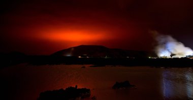 The red shimmer from magma flowing out from the erupting Fagradalsfjall volcano behind the landmark Blue Lagoon, some 45 kilometers west of capital Reykjavik, Iceland, March 19, 2021. (AFP Photo)