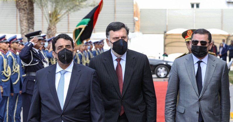 Mohammad Younes Menfi (L), head of Libya's presidency council, and new interim Prime Minister Abdul Hamid Dbeibah (R), arrive with outgoing GNA head Fayez al-Sarraj (C) for the formal handover, at the Presidential Council headquarters in Libya's capital Tripoli on March 16, 2021. (AFP Photo)
