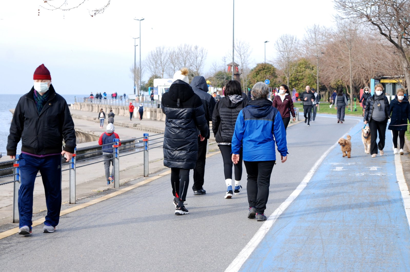 People wearing masks jog near the coastline in Istanbul's posh Caddebostan district, Turkey, March 20, 2021. (AA Photo)