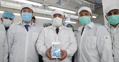 Industry and Technology Minister Mustafa Varank shows an Oppo phone produced in Turkey during his visit to the factory, Istanbul, Turkey, March 8, 2021. (Photo by the Industry and Technology Ministry via AA)