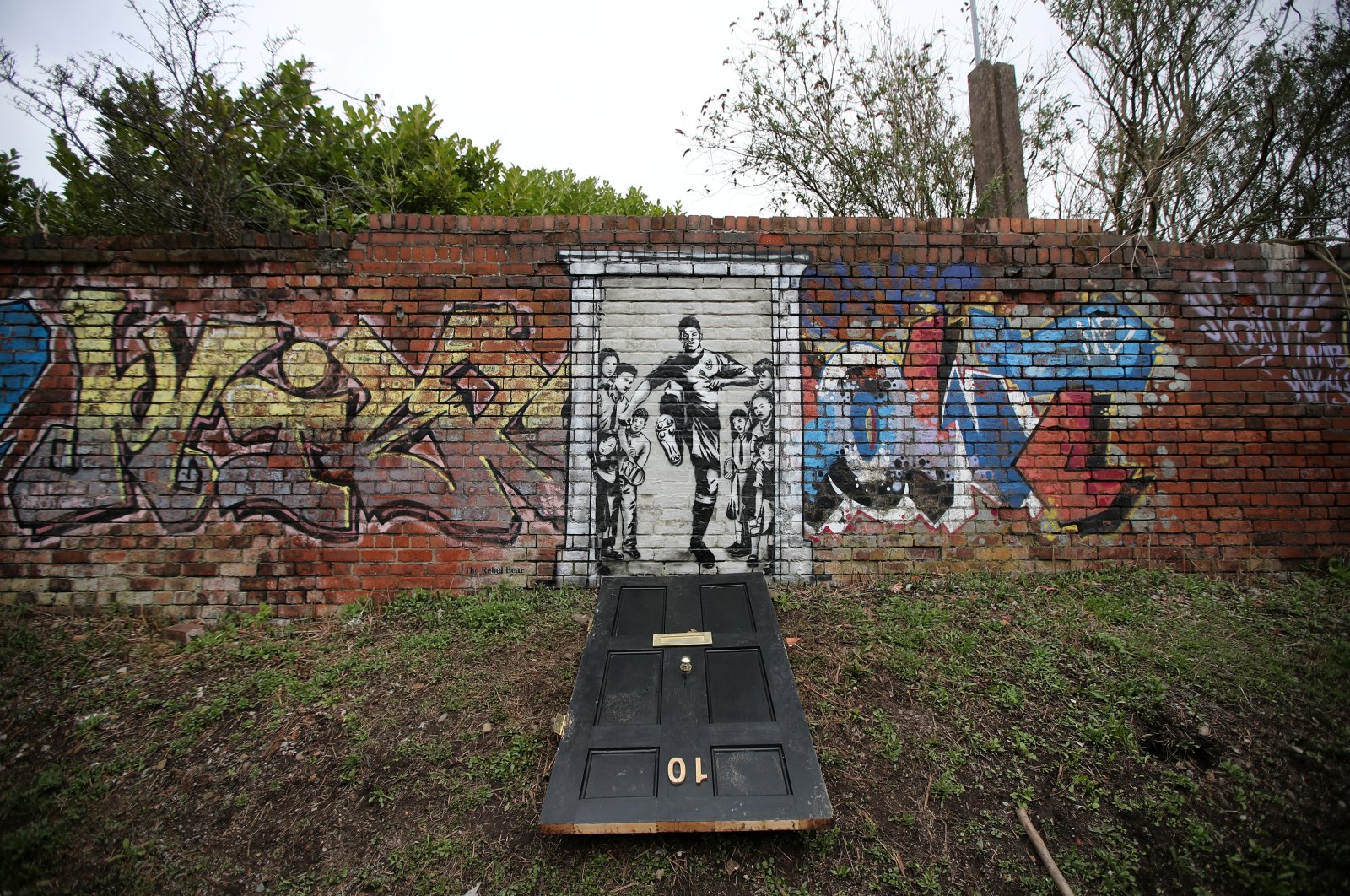 A mural of England footballer Marcus Rashford kicking down the door of No. 10 Downing St. appears on Manchester Canal in Manchester, Britain, March 21, 2021. (Reuters Photo)