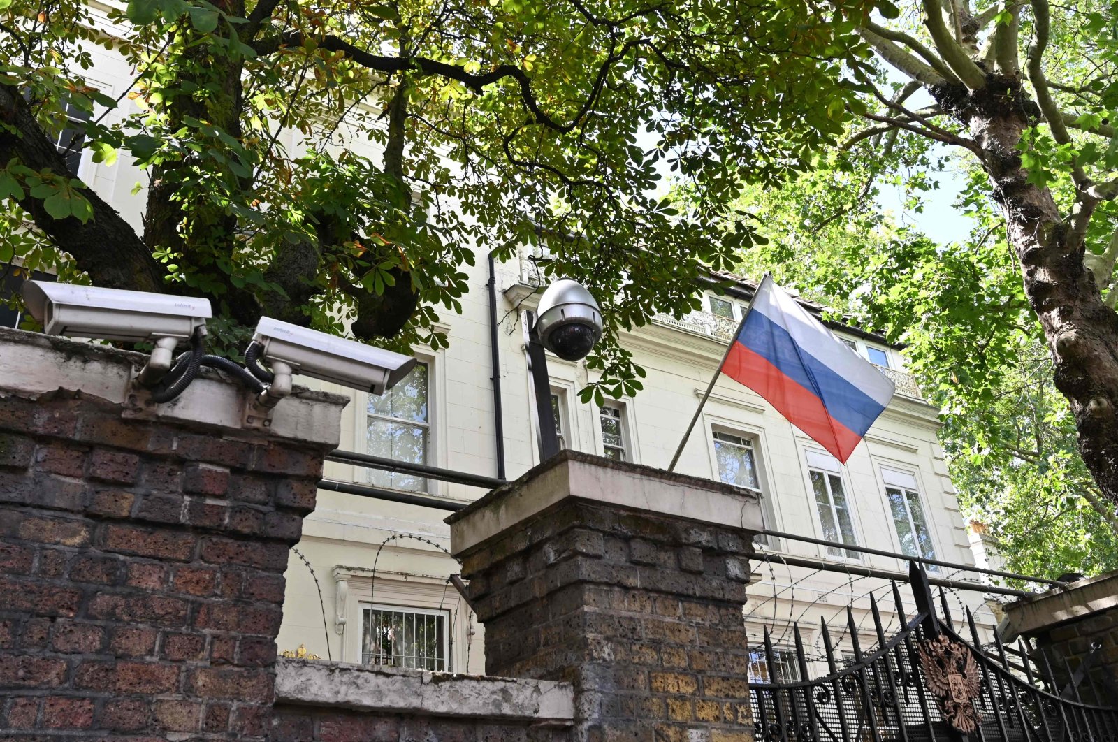 A Russian flag flies by surveillance cameras at the entrance to the Russian consulate in London, July 21, 2020. (AFP Photo)