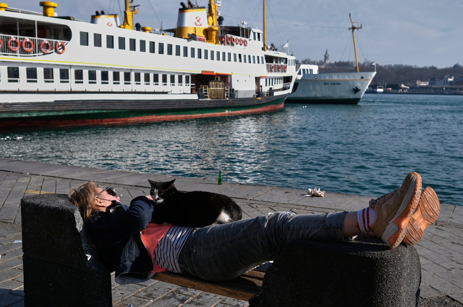 A tourist takes a nap on a bench by the Bosporus during a local Sunday lockdown imposed to slow the rate of the coronavirus contagion in Istanbul, Turkey March 14, 2021. (Reuters Photo)