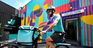A biker working for the Food delivery service Deliveroo cycles off to deliver an order in Saint-Ouen, outside Paris, July 3, 2018. (AFP Photo)