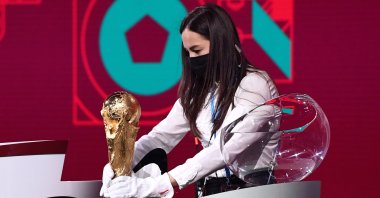 A member of staff cleans the World Cup Trophy prior to the Preliminary Draw of the 2022 Qatar FIFA World Cup, Zurich, Switzerland, Dec. 07, 2020. (Getty Images)