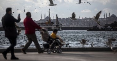 People walk along the Bosporus as seagulls fly above amid the coronavirus, Istanbul, Turkey, March 16, 2021. (Photo by Getty Images)