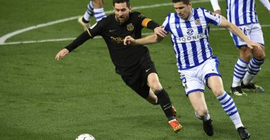 Barcelona's Lionel Messi (L) fights for the ball against Real Sociedad's Igor Zubeldia during the Spanish La Liga match at Reale Arena stadium, San Sebastian, Spain, March. 21, 2021. (AP Photo)